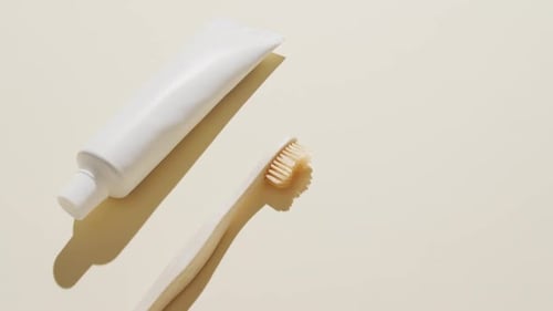 Close up of toothpaste and toothbrush on beige background with copy space