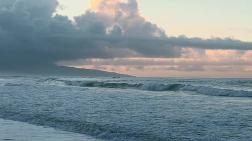 Deserted Beach with Strong Waves and a Cloudy Sunset Sky