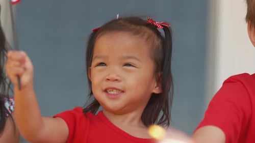 Smiling Child Waving American Flag During Celebration