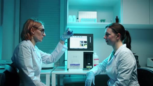 Medical Professionals Analyzing Blood Sample in Laboratory