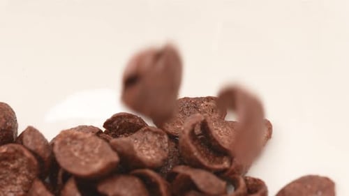 Chocolate Cornflakes Falling into a Bowl Close Up