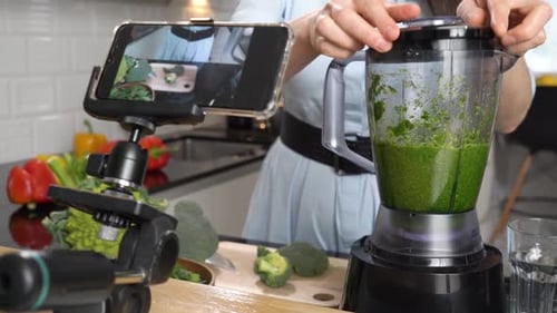 Woman Prepares Green Smoothie in Kitchen