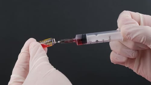 Drawing Red Liquid into Syringe from Vial