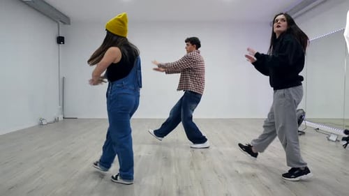 Energetic dancers performing choreography in dance studio