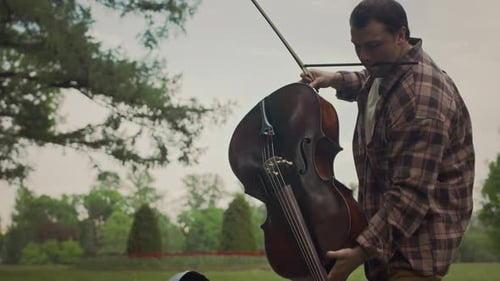 Musician Preparing Cello for Outdoor Performance in Park