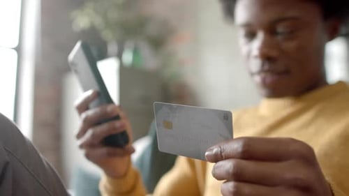 Young Adult Shopping Online Using Phone and Credit Card