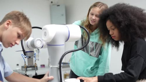 Diverse schoolkids working on robotic technologies at STEM educational class.