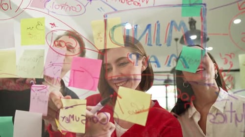 Team Brainstorming Together, Writing on Glass Board in Office