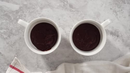 Schritt für Schritt flach legen und den Schokoladenkuchenteig in die Förmchen gießen, um den Schokoladenbecherkuchen zuzubereiten