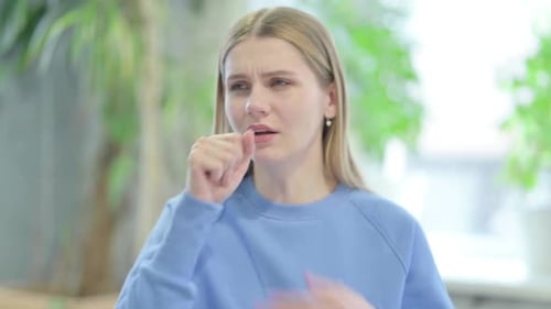 Young Woman Coughing Indoors, Close Up