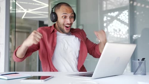 Excited Young Adult Celebrating Success With Laptop