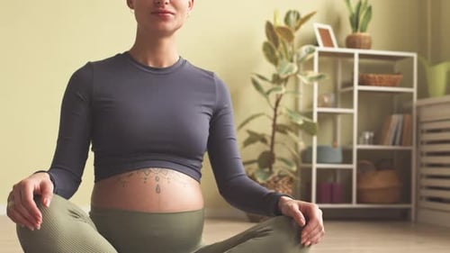 Pregnant Woman Sitting Cross-Legged on Yoga Mat
