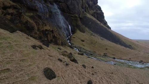 Drone flying to small waterfall in the mountain in Iceland