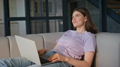 Woman Using Laptop on Couch Indoors