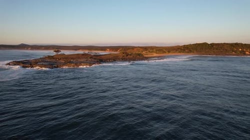Ocean Waves Hitting The Rocky Coastline Of Angourie Point Beach During Sunrise In NSW, Australia. -