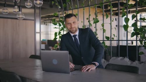 Portrait of Male Businessman Working in a Modern Office at a Laptop Portrait of a Male Boss in a