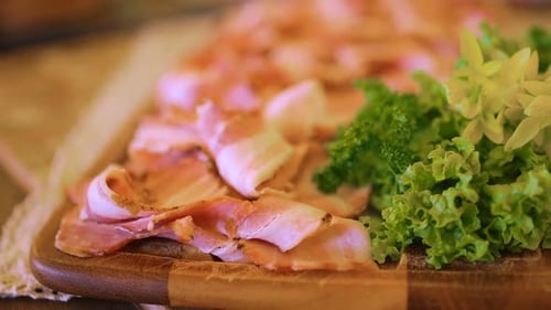 Geschnittenes geräuchertes Fleisch auf hölzernem Servierbrett
