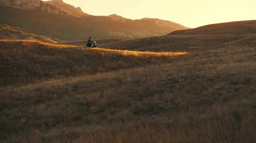 ATV Rider at Sunset in Grassy Landscape