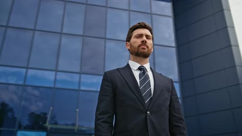 Serious Boss Standing Outside Modern Office with Confident Expression Closeup