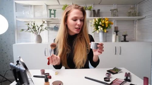 Mujer bloguera de belleza filmando un tutorial diario de rutina de maquillaje ante la cámara en un trípode, la influencer Lady Live