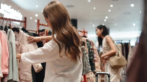 Young Woman Choosing Clothes Shopping in a Fashion Boutique