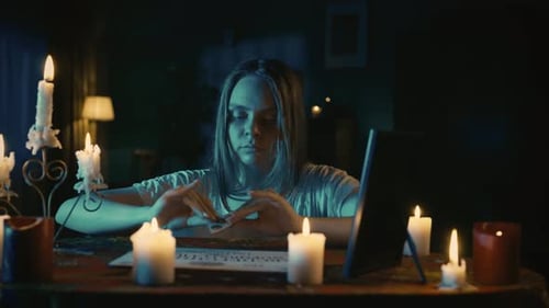 Video of a Young Woman Sitting at the Table Having Ouija Board Session Paranormal Activity Begins to