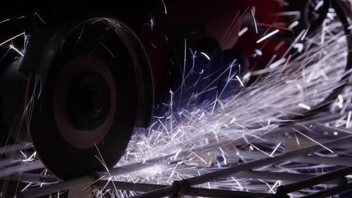Closeup view: Cut-off disc cuts steel racking, sending sparks flying