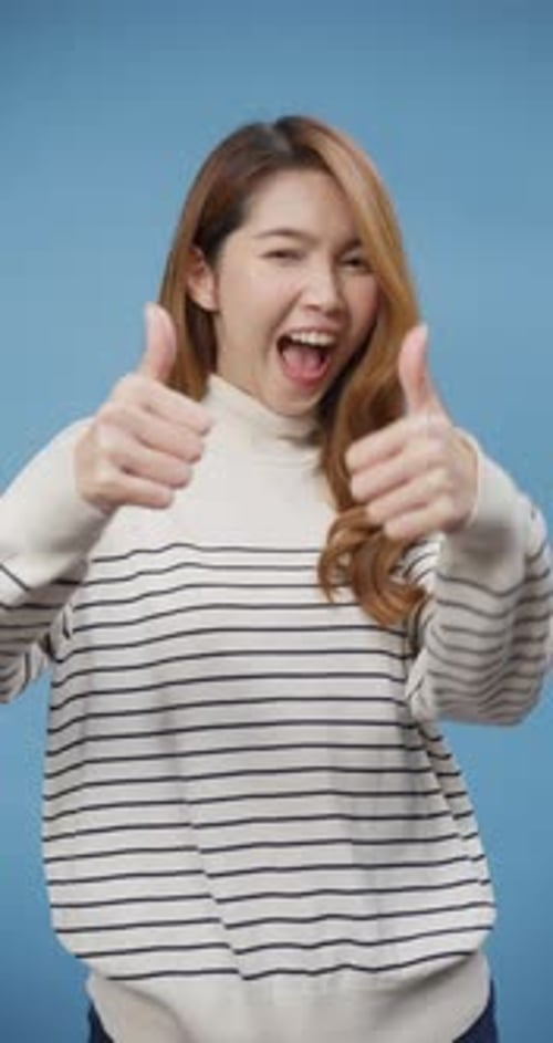 lady wear sweater stand show thumb up over isolate blue background happy face show perfect.