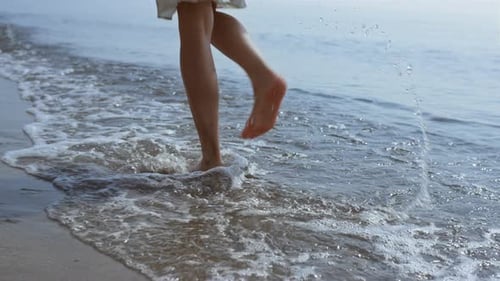 Bare Woman Legs Jumping on Sea Waves Close Up. Unknown Young Lady