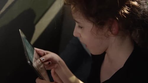 kids riding the school bus to class - Young girl playing tablet computer game