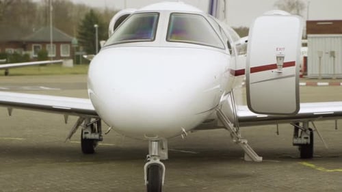 Plan panoramique montrant un jet privé de luxe dont les portes sont ouvertes lors de l'embarquement. Cessna Citation Jet pendant la journée