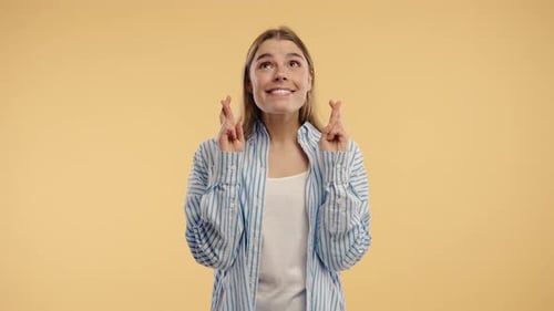 Smiling Woman Crossing Fingers with Hopeful Expression