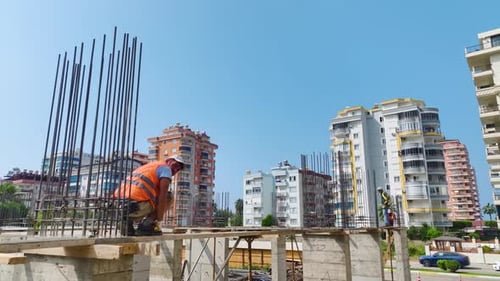 Luftaufnahme einer Baustelle mit Arbeitern, die Beton für ein Gebäudefundament gießen