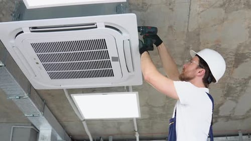 Tradesman Installing Air Conditioner in Industrial Setting