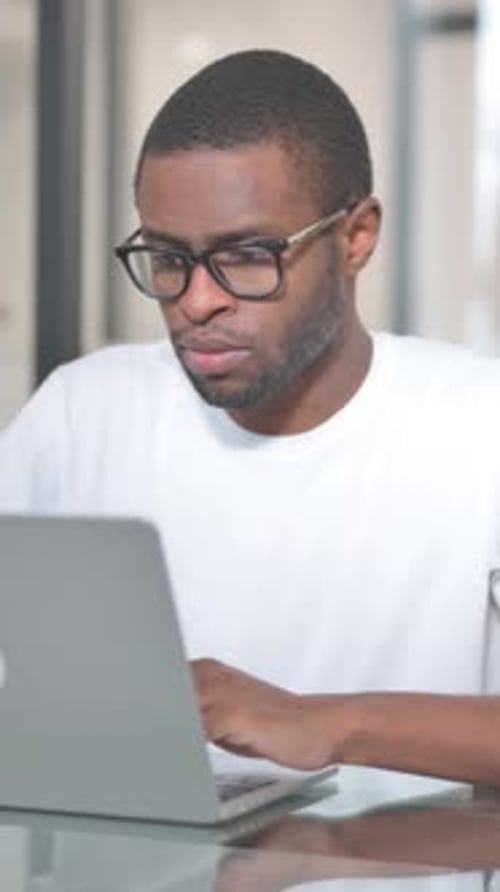 Focused Man Working on Laptop Computer Indoors