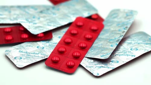 Red Pills in Blister Packs on White Background