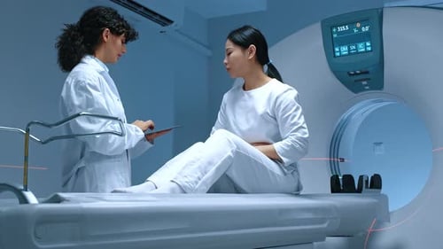 Doctor Consults Patient Next to CAT Scan Machine