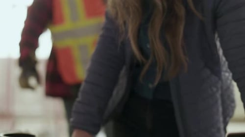 Architects Reviewing Blueprints on Construction Site Together