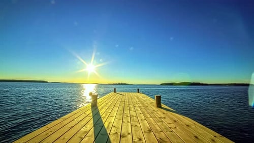 Zeitraffer der golden untergehenden Sonne über einem Angelsteg an einem tropischen Strand mit Meerwasser im
