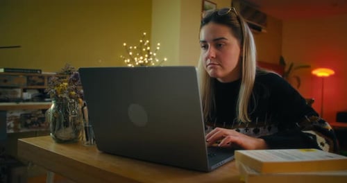 Woman Using Laptop at Table in Home Interior
