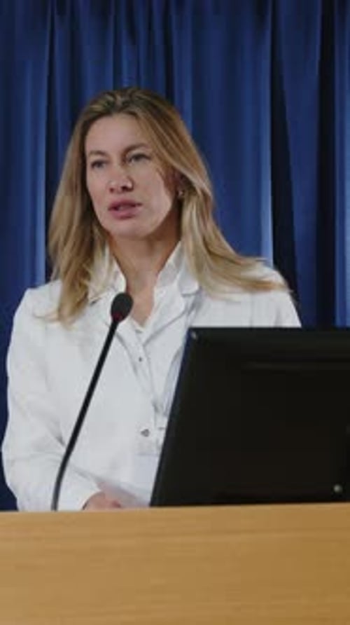 Woman Giving a Conference Presentation Behind a Podium