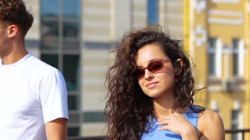 Close Up of Beautiful Young Caucasian Woman with Curly Hair in Sunglasses Drinking Beer on Sunny Day