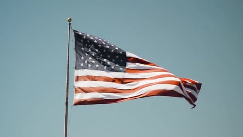 American Flag Waving Against Clear Blue Sky