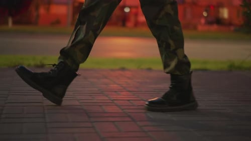 Steady Pace Through City Streets Unwavering Soldier Moves Under Streetlights Resolute Veteran