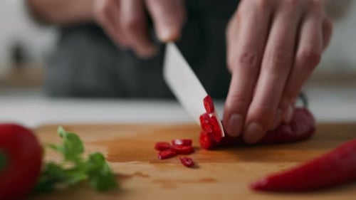 Adult Cutting Fresh Red Pepper on Cutting Board