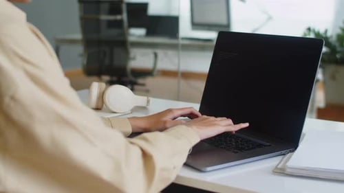 Female Software Engineer Writing Code Using Laptop at Office