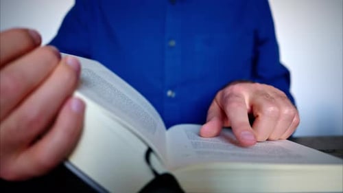 Nahaufnahme eines Mannes, der ein großes Buch liest