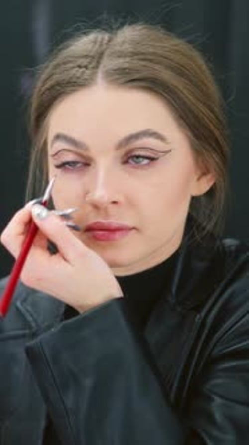 Woman Making Up the Eyes with Eye Liner Indoors