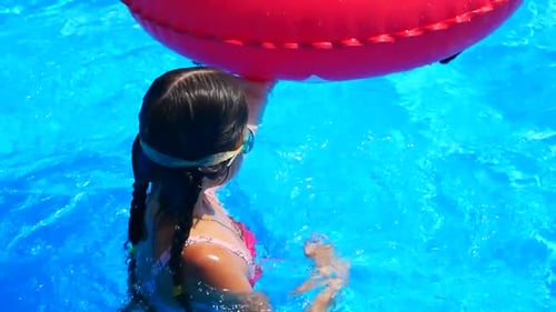 Little Girl Jumps Into an Inflatable Circle with a Pool Side Children Have Fun and Play Dives on the