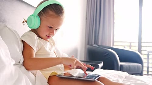 Young Girl Uses Tablet in Hotel Room
